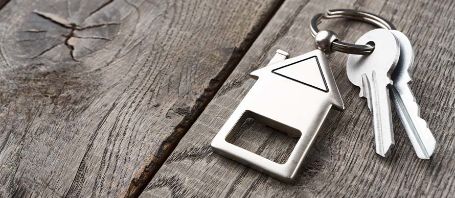 bunch-of-keys-with-house-shaped-keychain-on-rustic