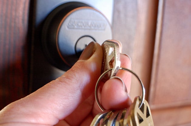 hand-unlocking-dead-bolt-on-door-with-set-of-keys